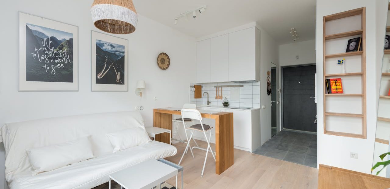 Revente LMNP : comment la réussir ? Photo pour illustrer notre article montrant un appartement étudiant avec canapé-lit, bureau et kitchenette